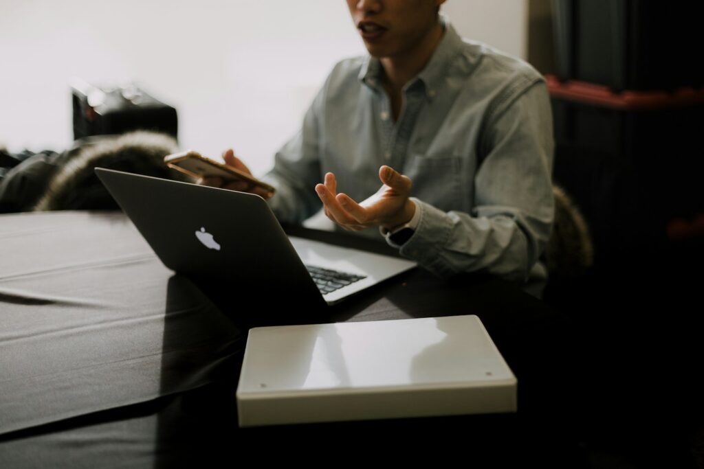 a man sitting at a table with a laptop in front of him