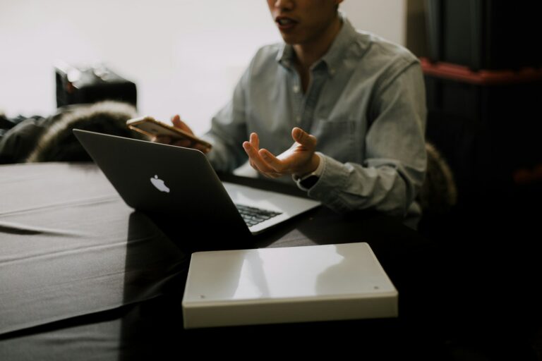 a man sitting at a table with a laptop in front of him